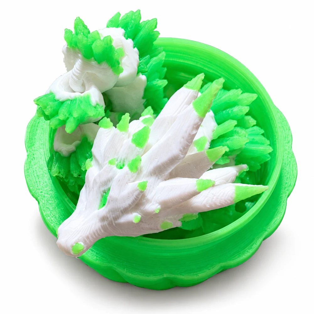 White-and-green articulated 3D printed dragon curled inside its green egg holder